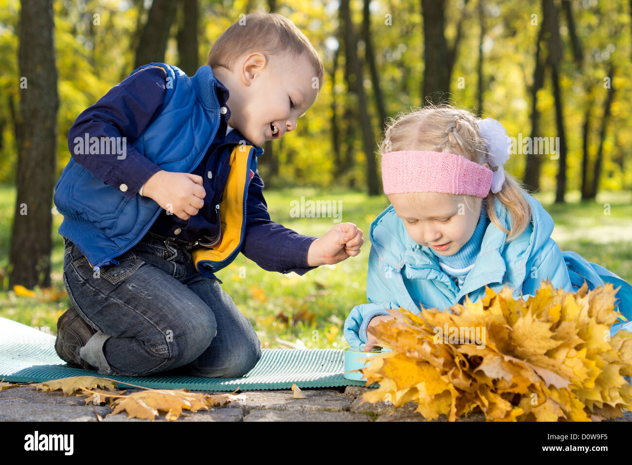 Cute young brother and sister playing in an autumn forest gathering ...