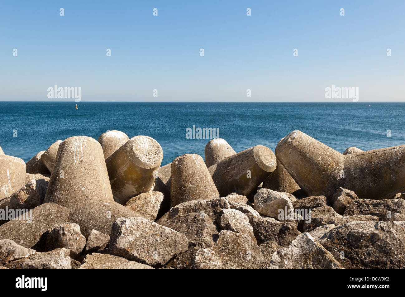 Concrete tetrapod breakwater in the shore near Sesimbra, Portugal Stock Photo