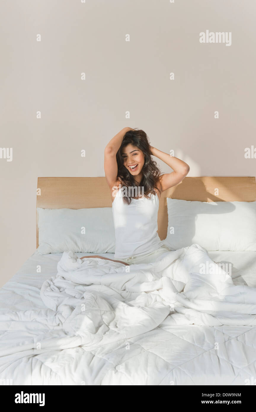 Woman sitting on the bed and smiling Stock Photo - Alamy