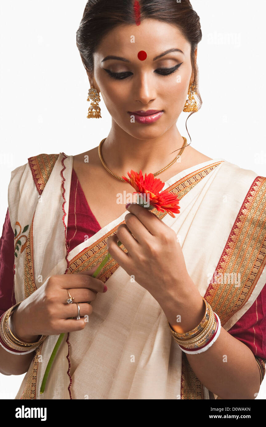 Bengali woman holding a Daisy flower and thinking Stock Photo Alamy