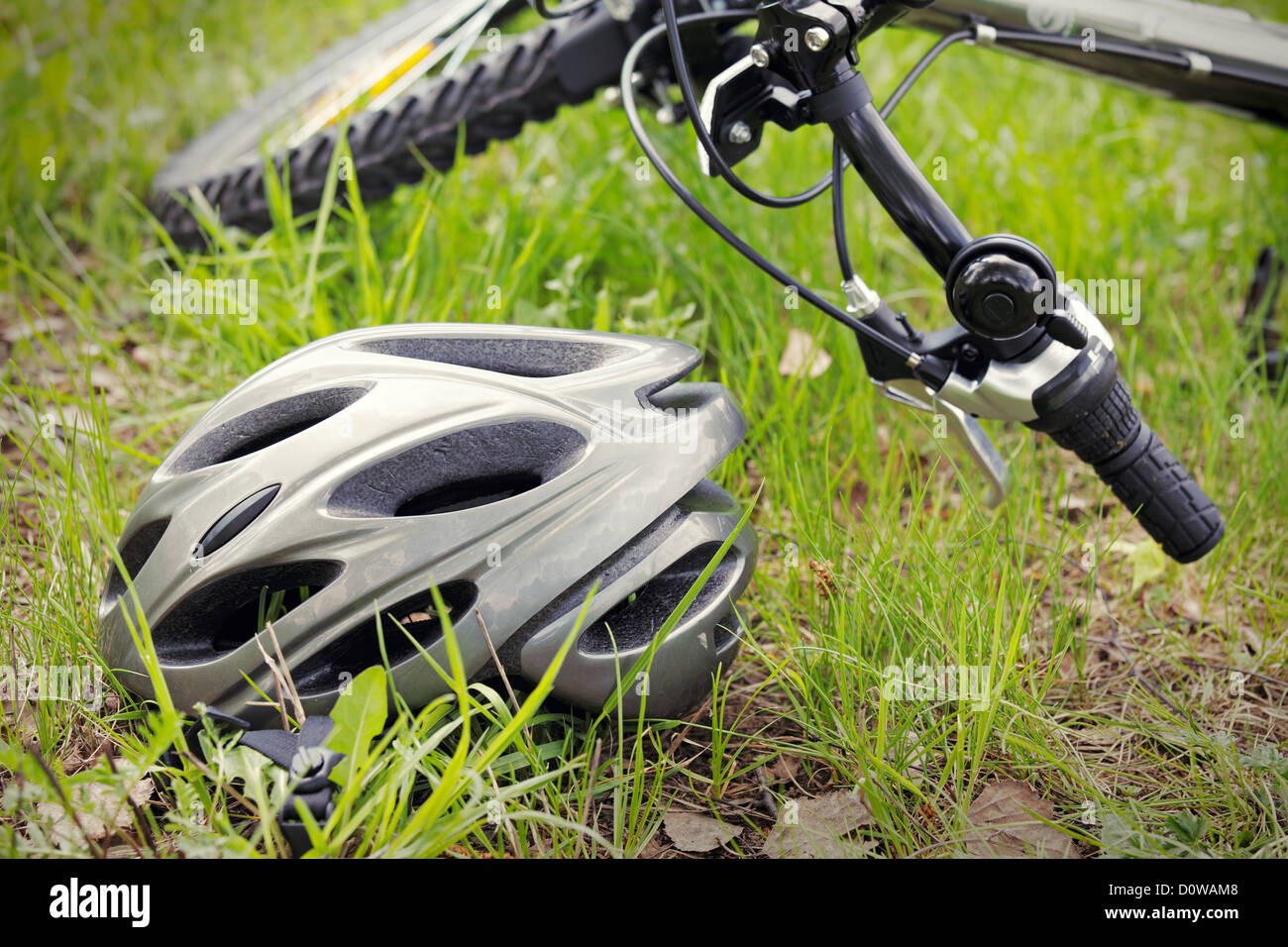 Helmet and bike on grass Stock Photo - Alamy