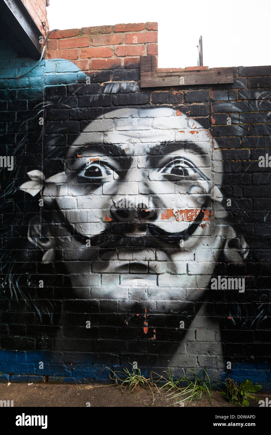 Salvador Dali like graffiti portrait painting on a brick wall. Stock Photo