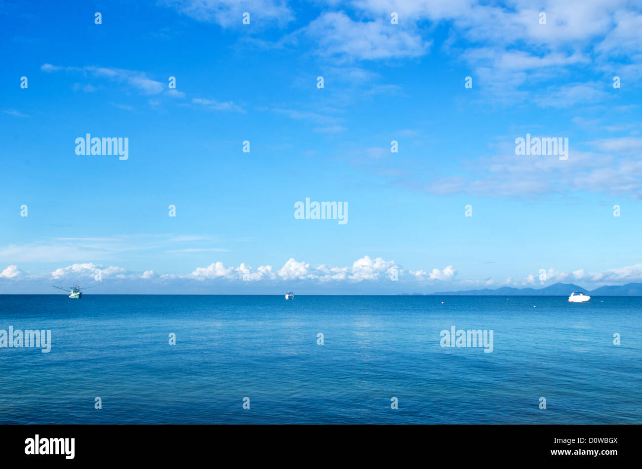cloudy blue sky above a surface of the sea Stock Photo
