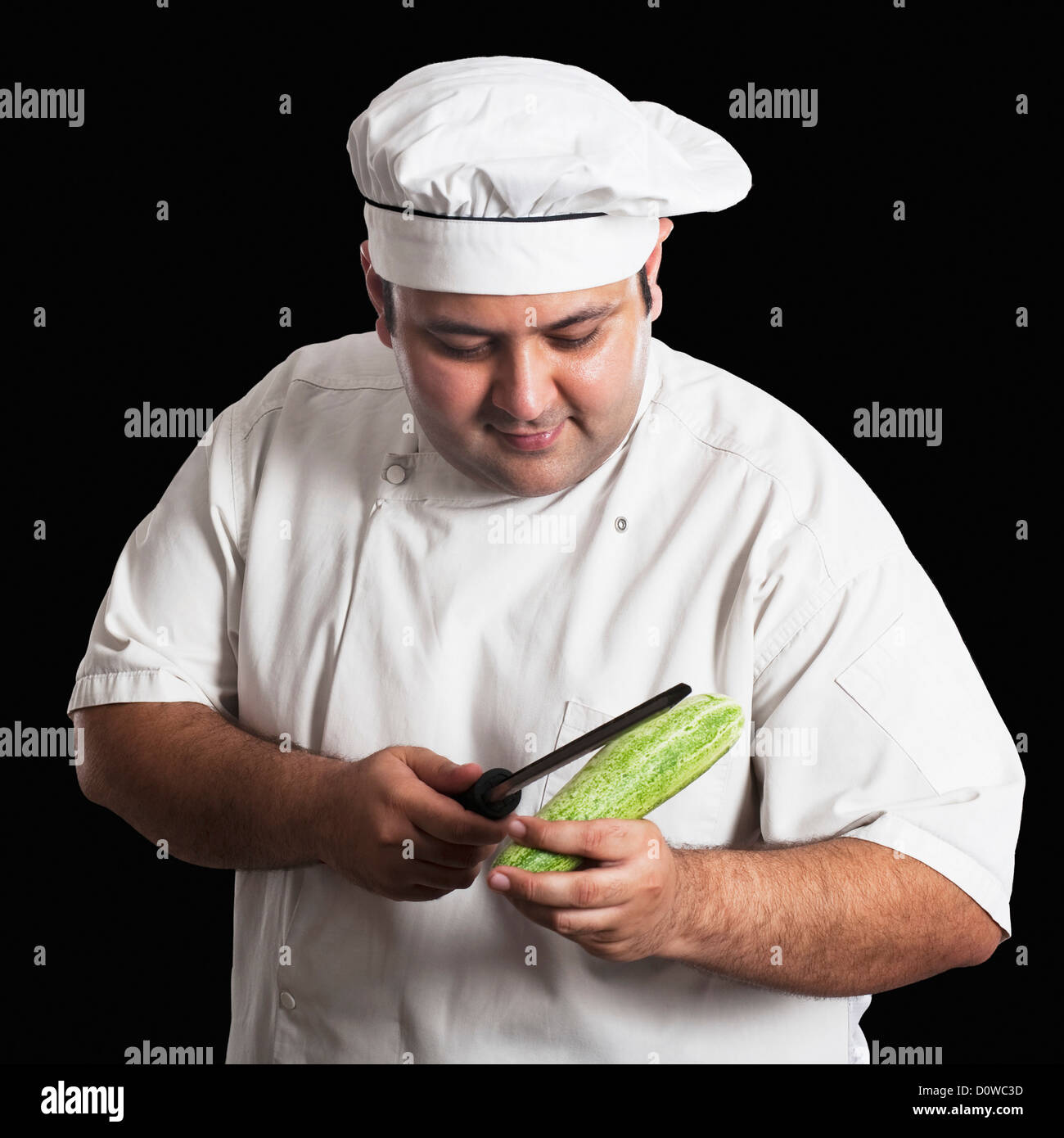 Man cutting a cucumber with a chef's knife. Thin slices of the
