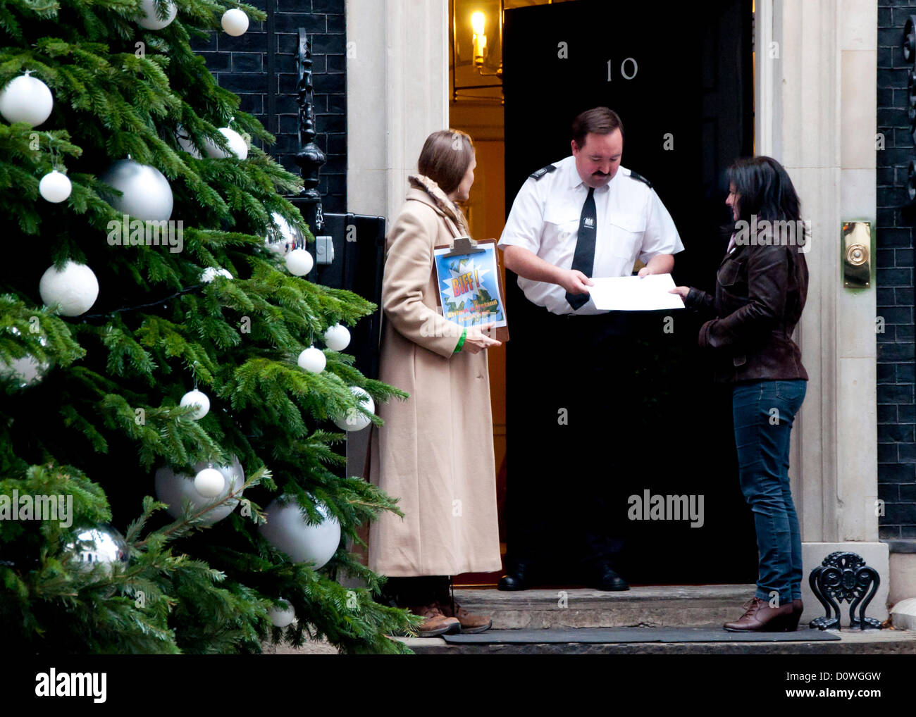 London, UK, 1 December 2012; Eve McNamara (right) of Ribble Estuary Against Fracking hands in a letter to 10 Downing Street addressed to UK Prime Minister David Cameron. Fellow protester Vanessa Vine stands at the other side of the door (left). A copy of the letter can be downloaded from http://www.frackfreefylde.com/open-letter-to-david-cameron/ Stock Photo