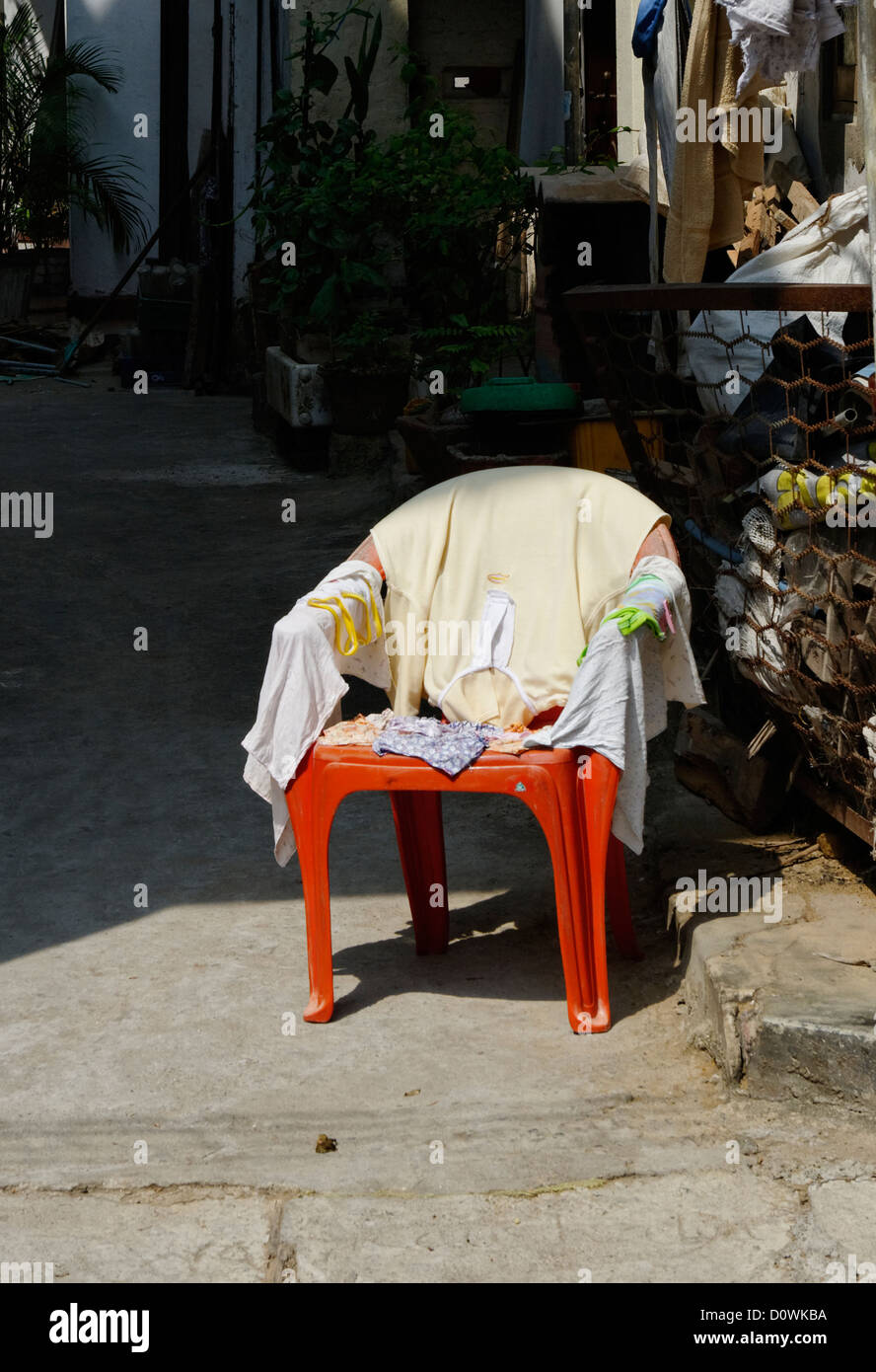 Red plastic chair covered in towels, Sri Lanka Stock Photo Alamy