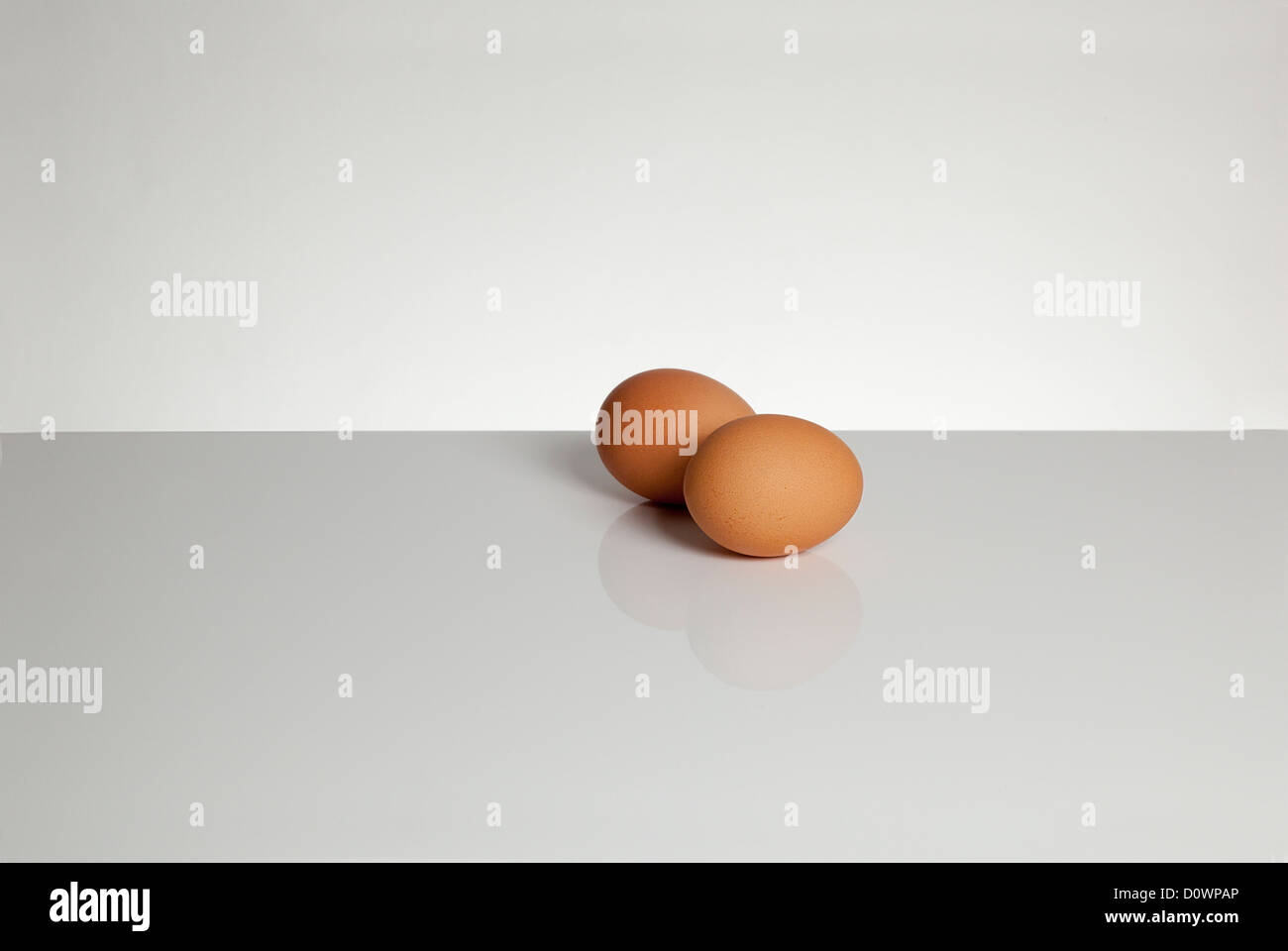 Two eggs on a grey surface. Space for type around. Landscape shape. Stock Photo