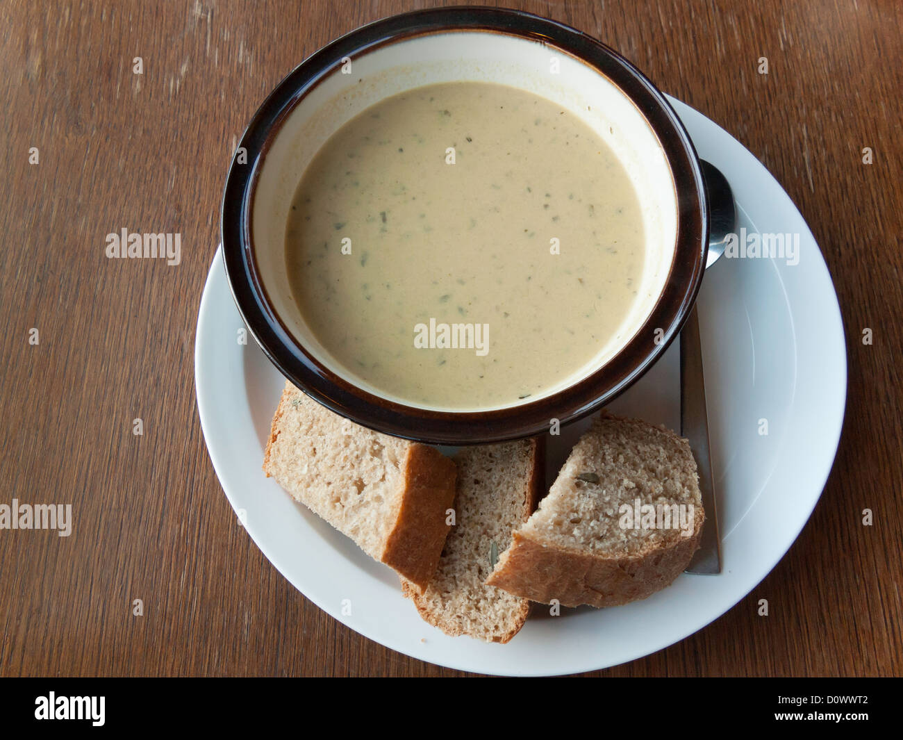 A slimmers lunch of courgette and herb soup and caraway bread on a vegetarian café table Stock Photo
