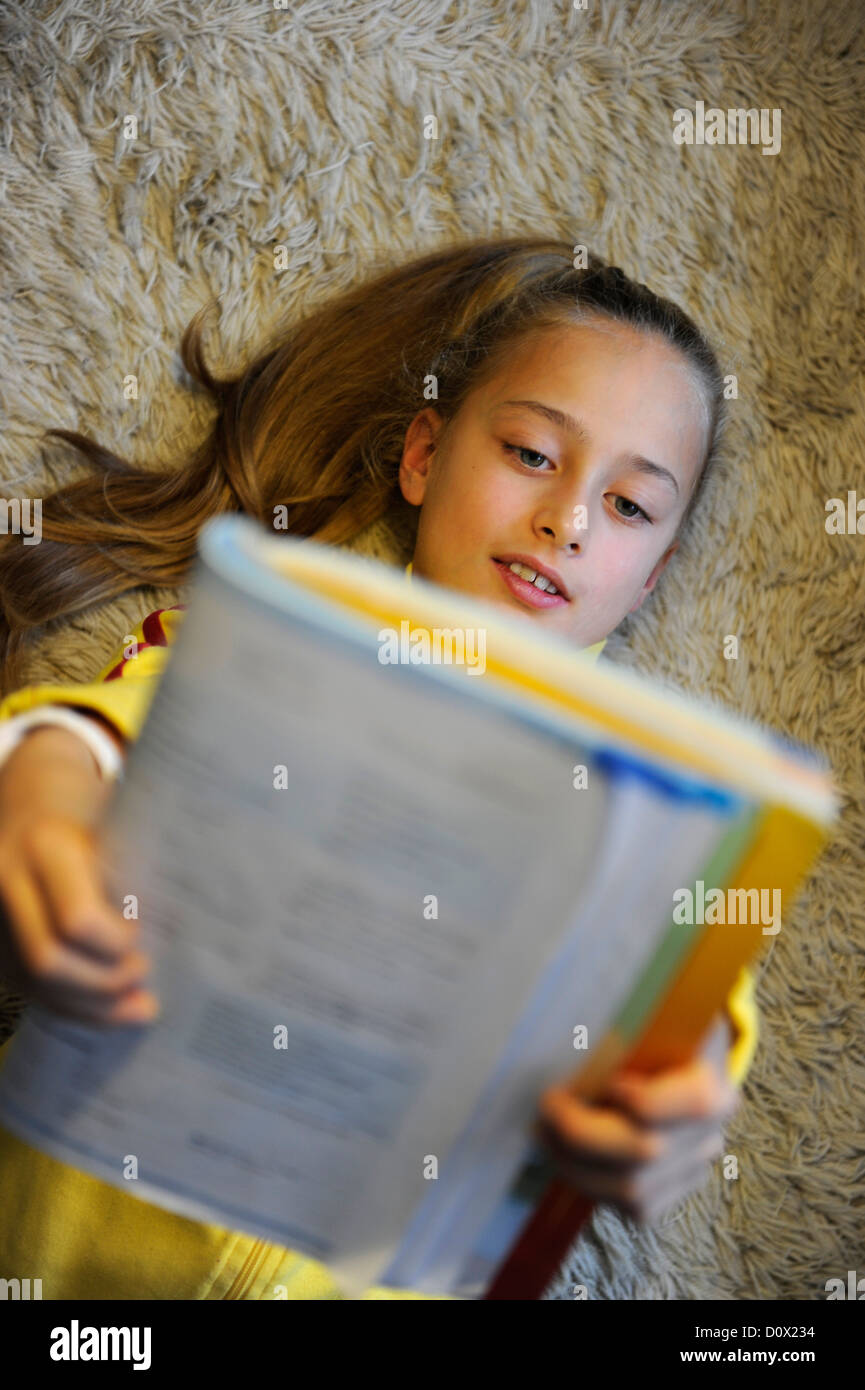 Girl of ten years beeing happy and satisfied reading. Stock Photo