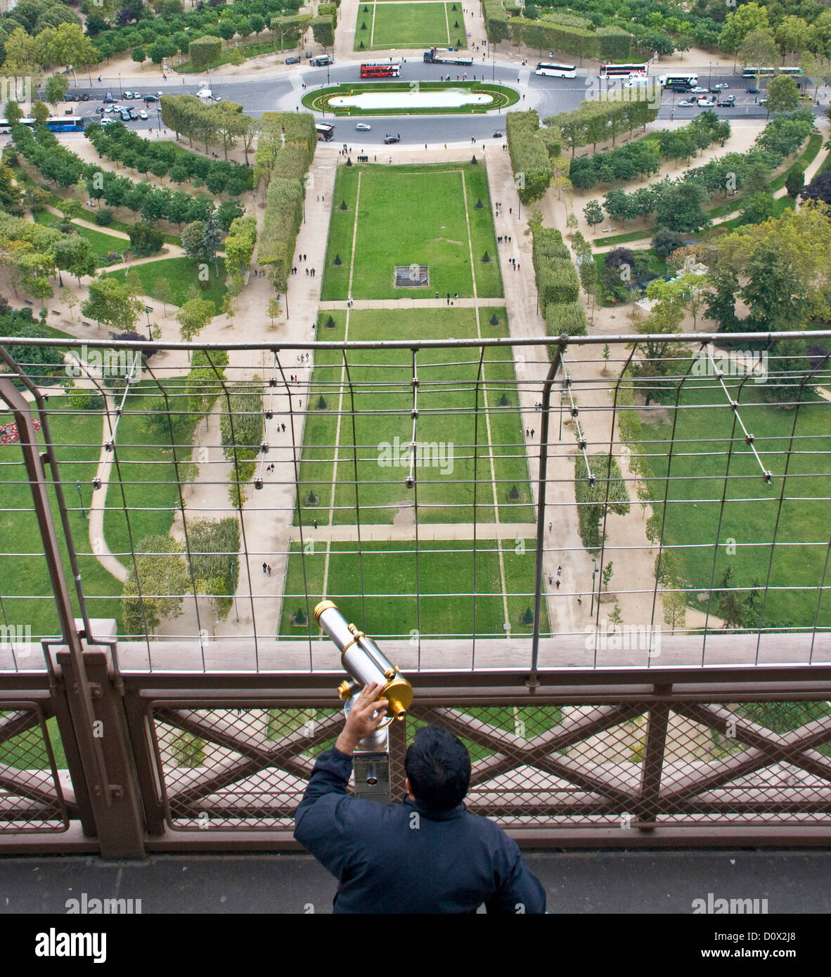 Tourist looking through telescope from Eiffel Tower observation platform Paris France Europe Stock Photo