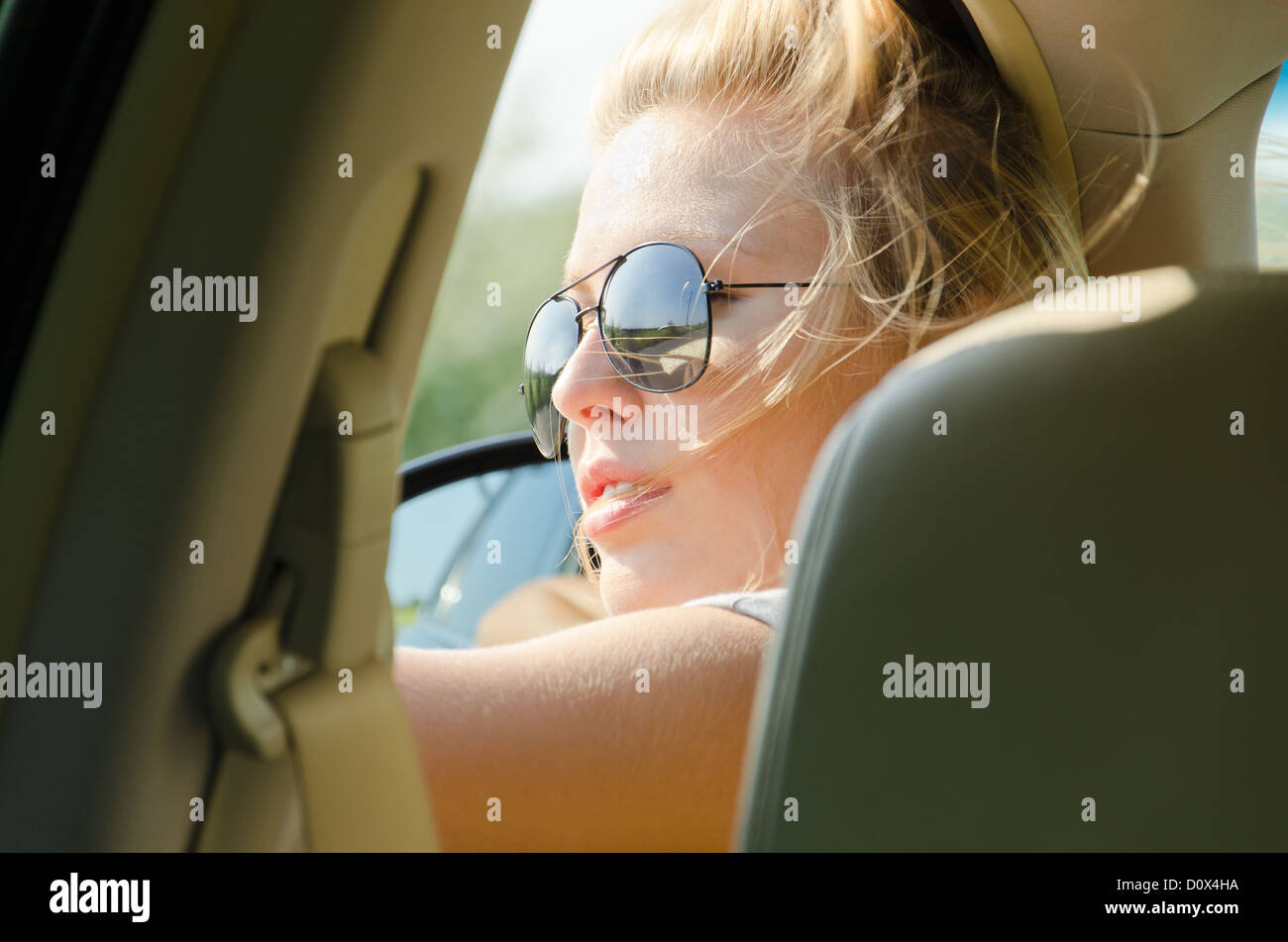 Close up portrait of blond female driver with sunglasses Stock Photo