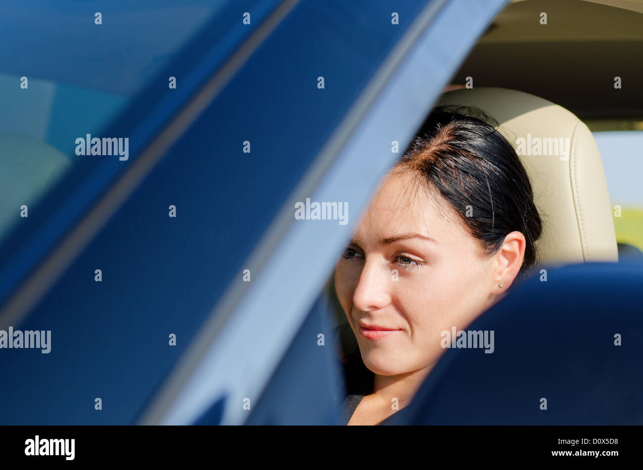 View through the window of a beautiful woman sitting in a car with her head resting on the headrest Stock Photo
