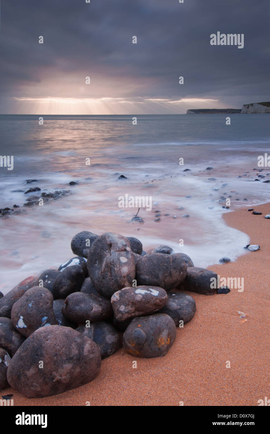 Distant light rays and a pile of boulders at Birling Gap, Eastbourne, East Sussex Stock Photo