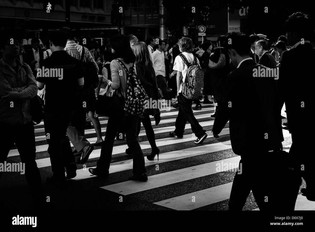 The well known zebra crossings near Shibuya station's Hachiko exit are swarming with people even at night Stock Photo