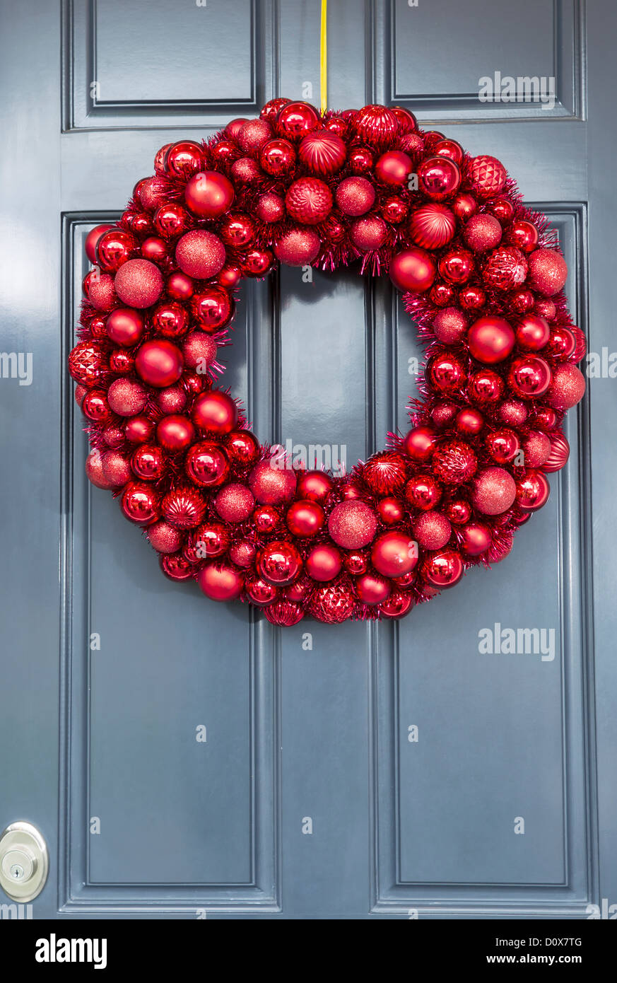 Red ball ornaments wreath hanging on outside of house door for holidays