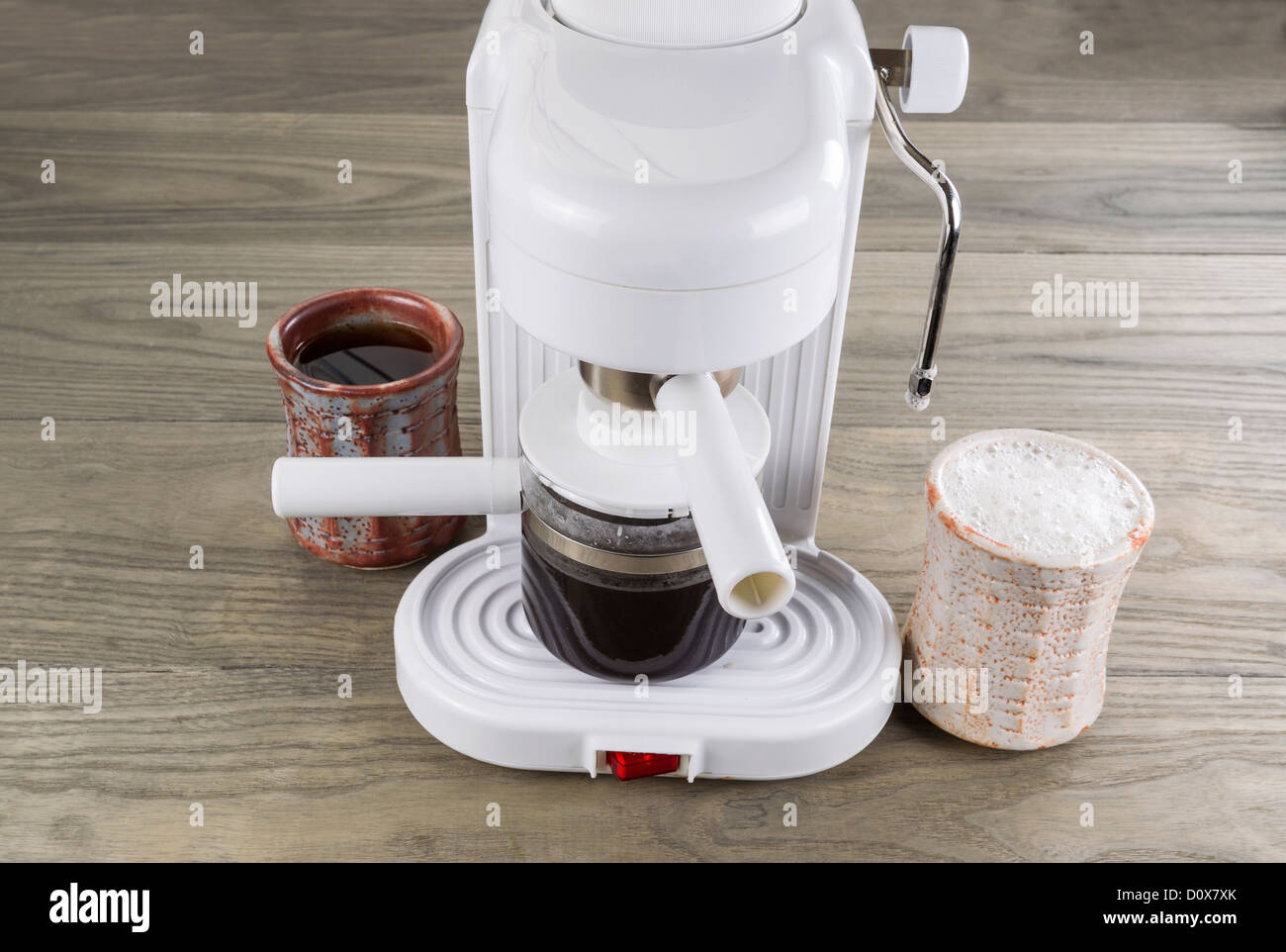 Espresso maker with drip black coffee and whipped latte coffee on