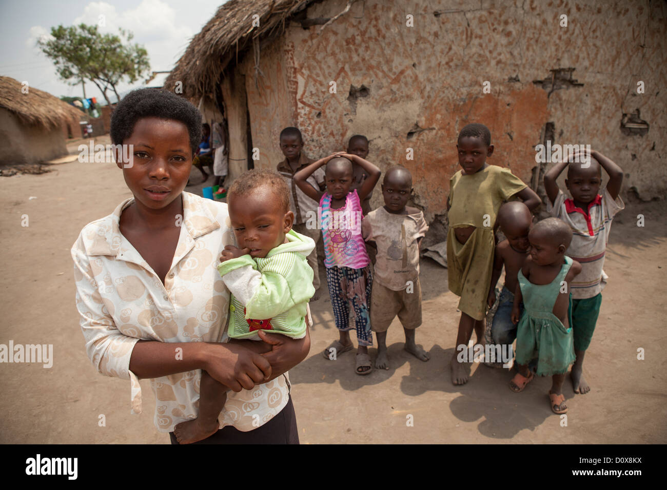 A young mother holds her child outside her house in Kasese, Uganda, East Africa. Stock Photo
