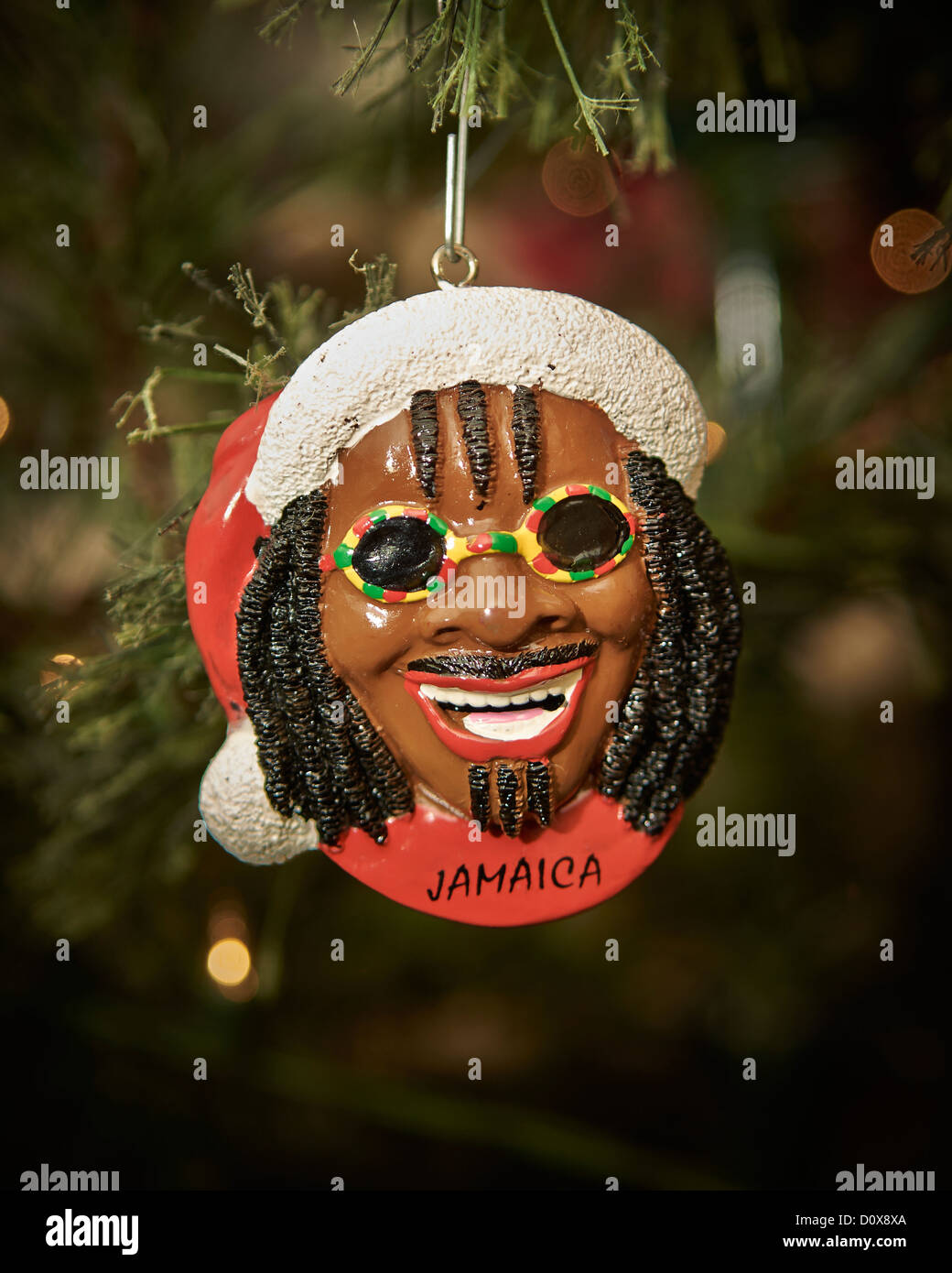 A Christmas tree ornament depicting a smiling African American male with dreadlocks and sunglasses, with the word Jamaica. Stock Photo