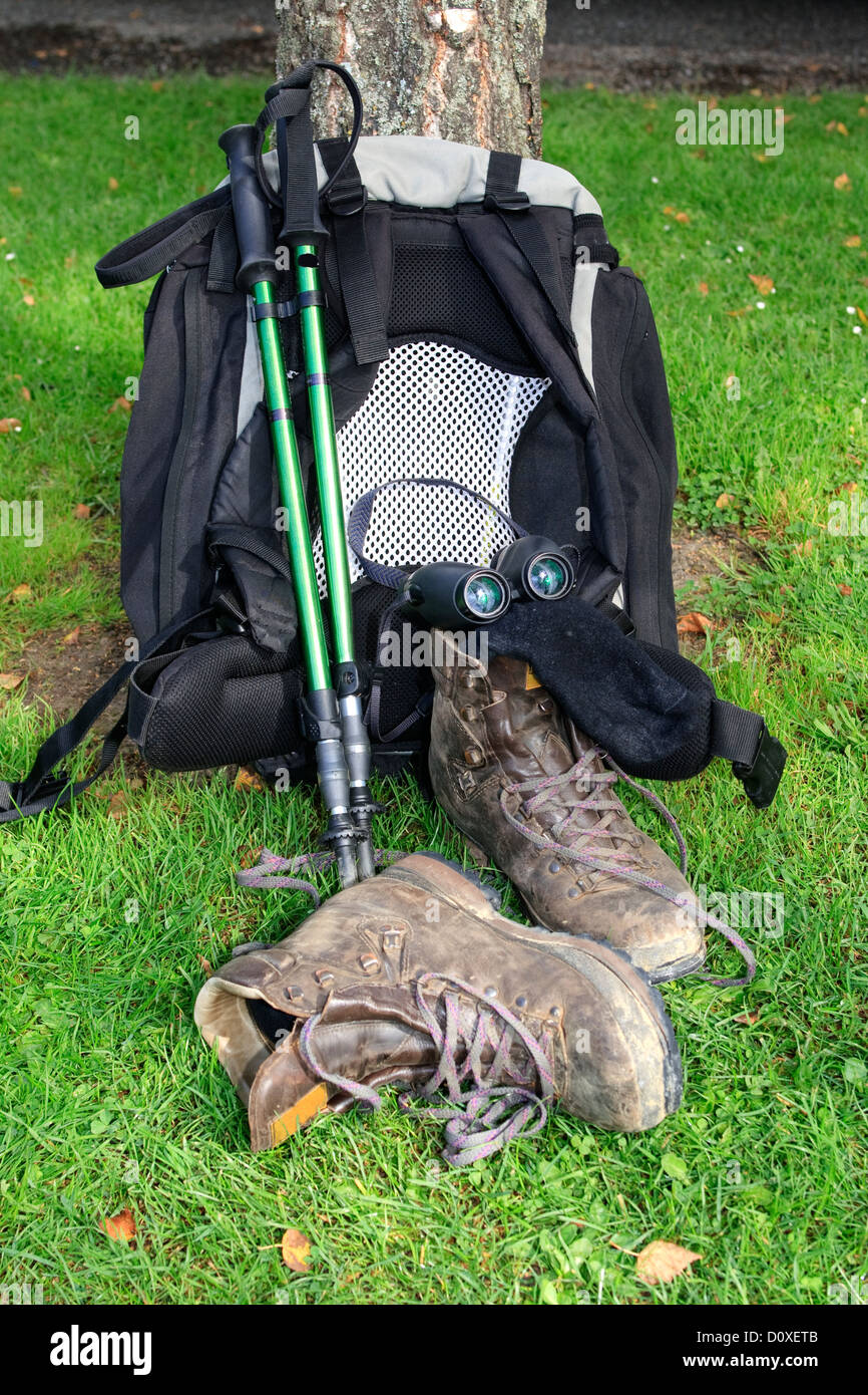 Backpack leaning against tree with hiking poles, hiking boots and socks ...