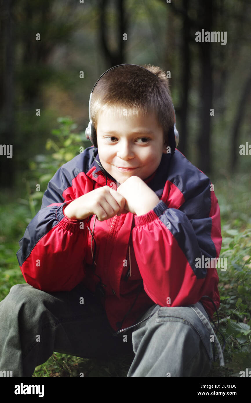 Boy in dark forest listens music Stock Photo - Alamy