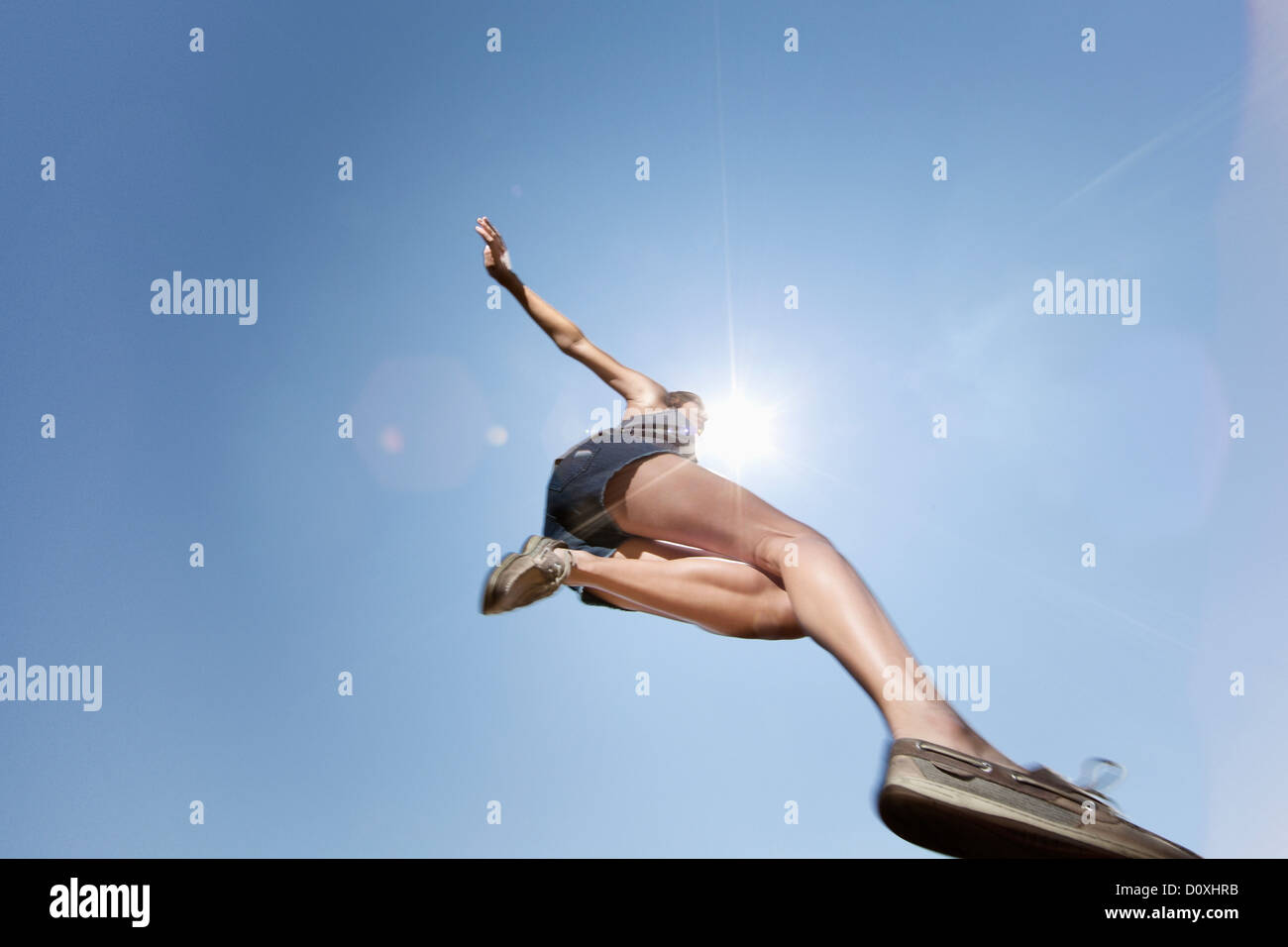 Girl jumping against blue sky, low angle Stock Photo
