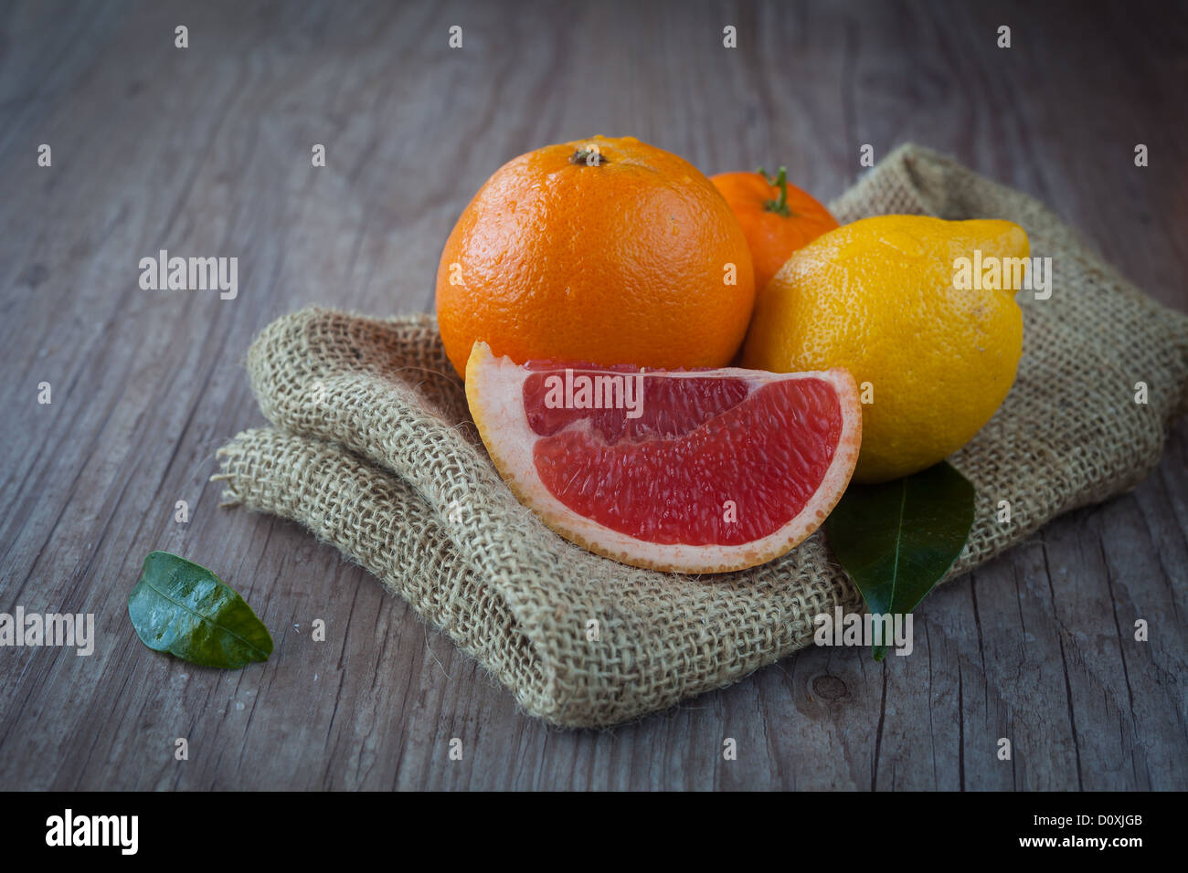 Bunch of fresh raw citrus fruits on a wooden background Stock Photo