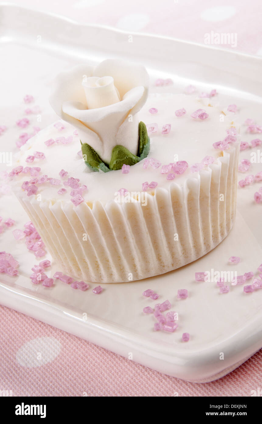 cupcake with white rose and pink sprinkles on a plate Stock Photo - Alamy