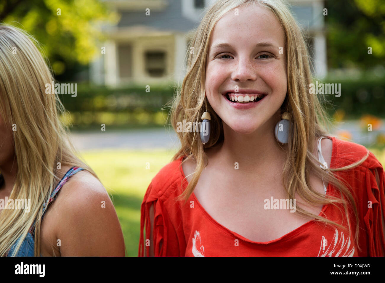 Portrait of blonde girl wearing earrings smiling to camera Stock Photo