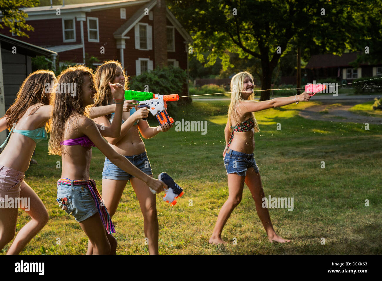 Girls having water fight with water pistols Stock Photo
