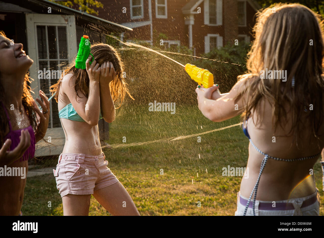 Girls having water fight with water pistols Stock Photo