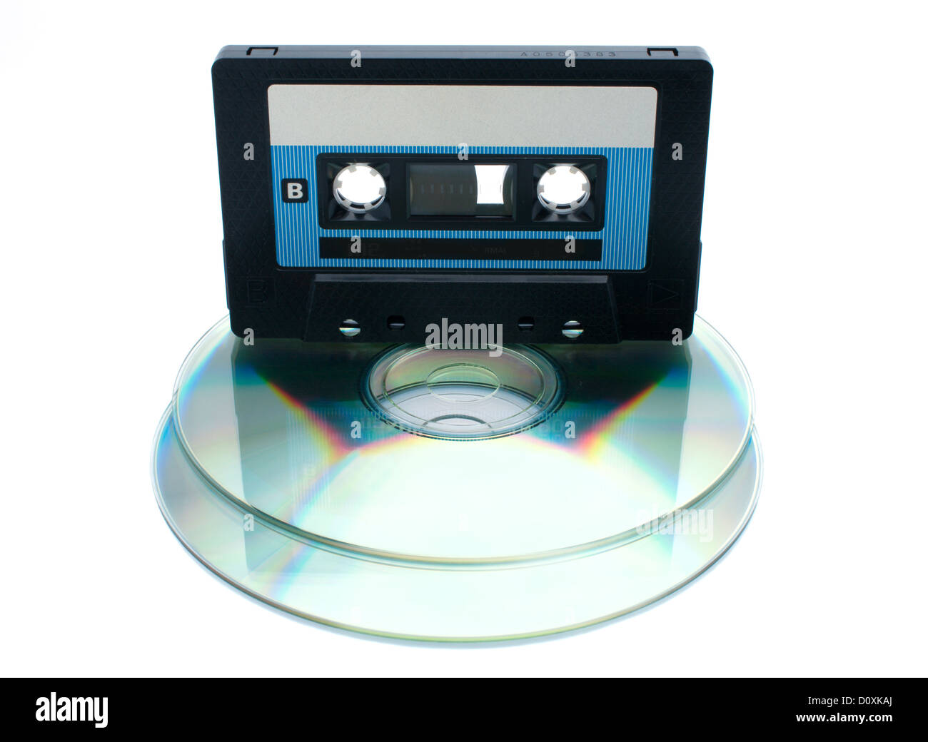 Analog audio tape cassette and digital compact disc on a white ...