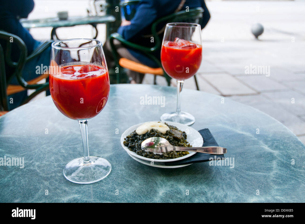 Two glasses of tomato juice and Spanish tapa of black rice with alioli