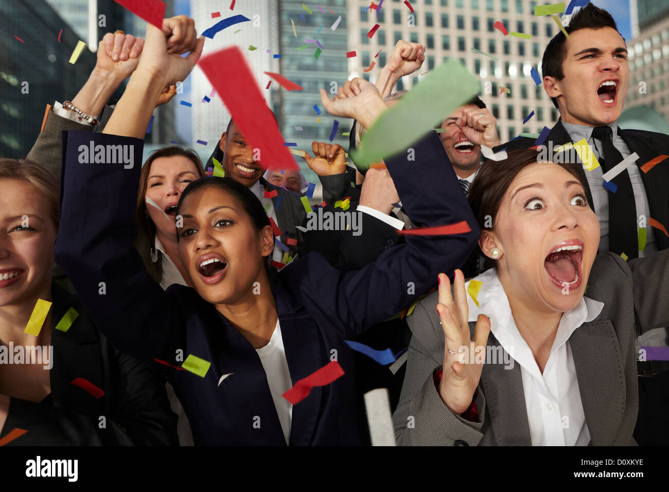 Businesspeople cheering as ticker tape falls Stock Photo