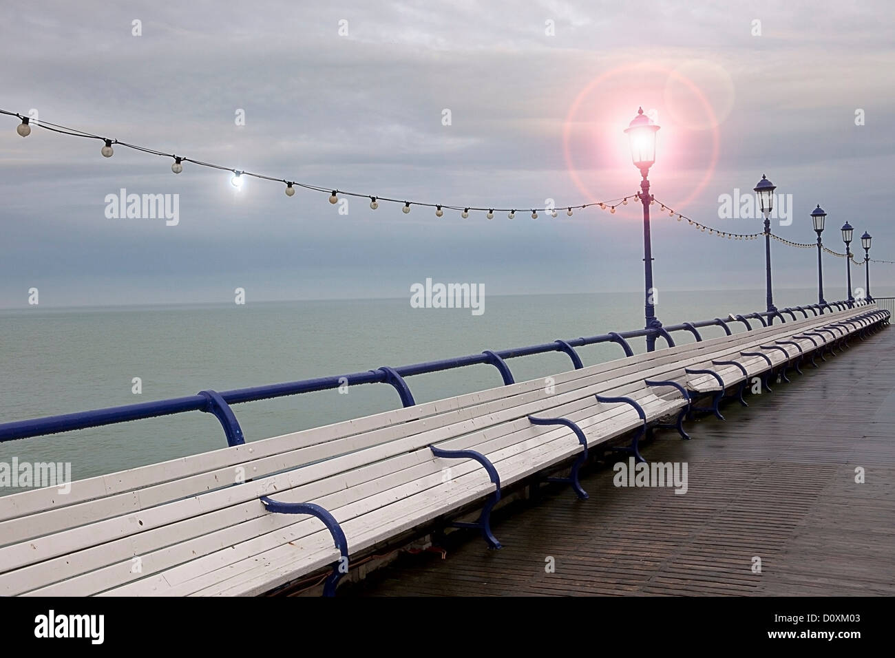 Empty benches on seaside pier, Eastbourne, East Sussex, UK Stock Photo
