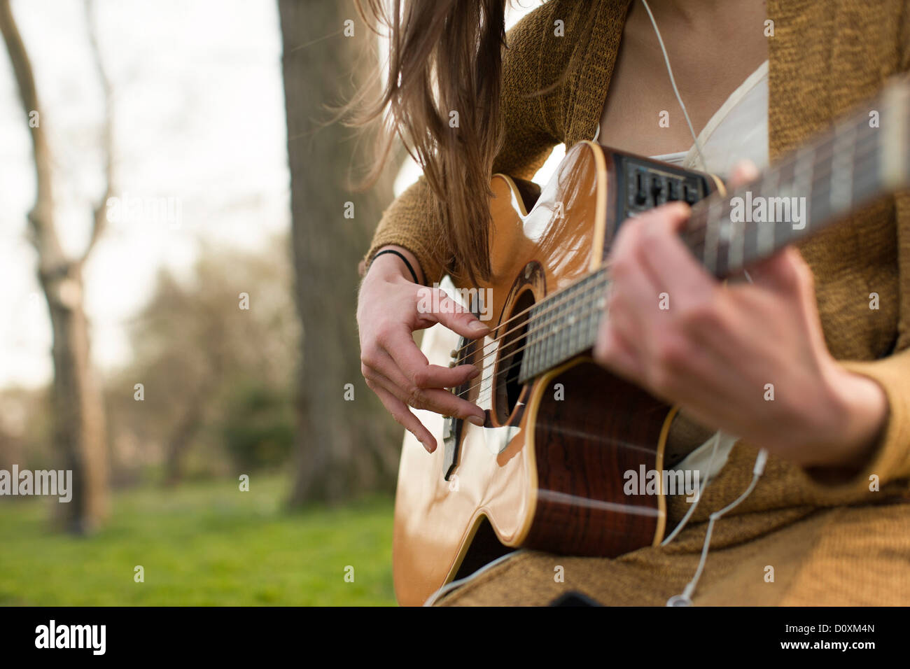 Young woman playing guitar outdoors Stock Photo - Alamy