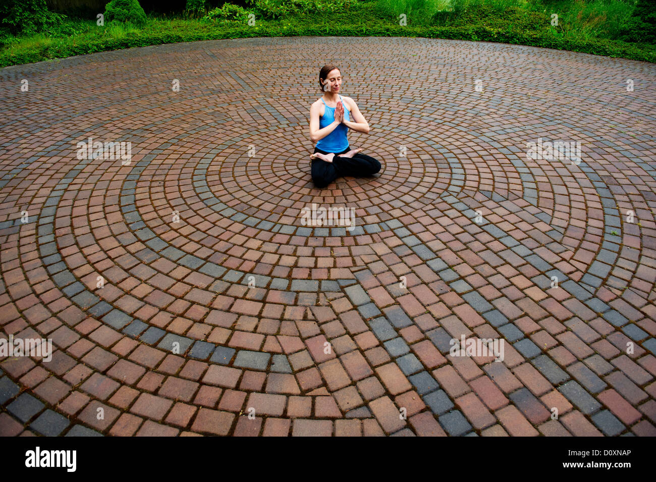 Woman meditating in paving stone circles Stock Photo