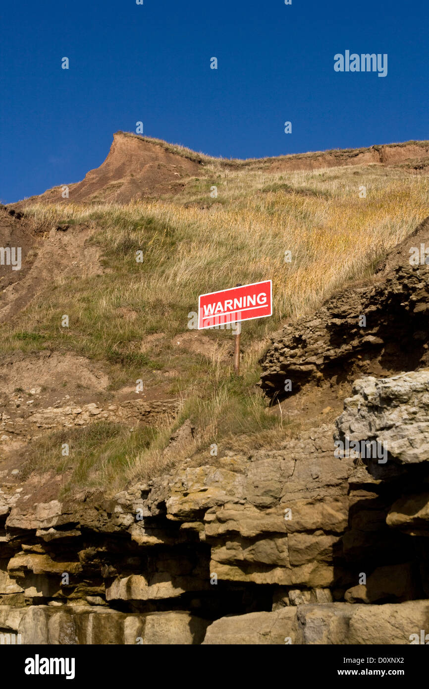 Warning sign post for dangerous cliffs, Filey Brigg, North Yorkshire, England Stock Photo
