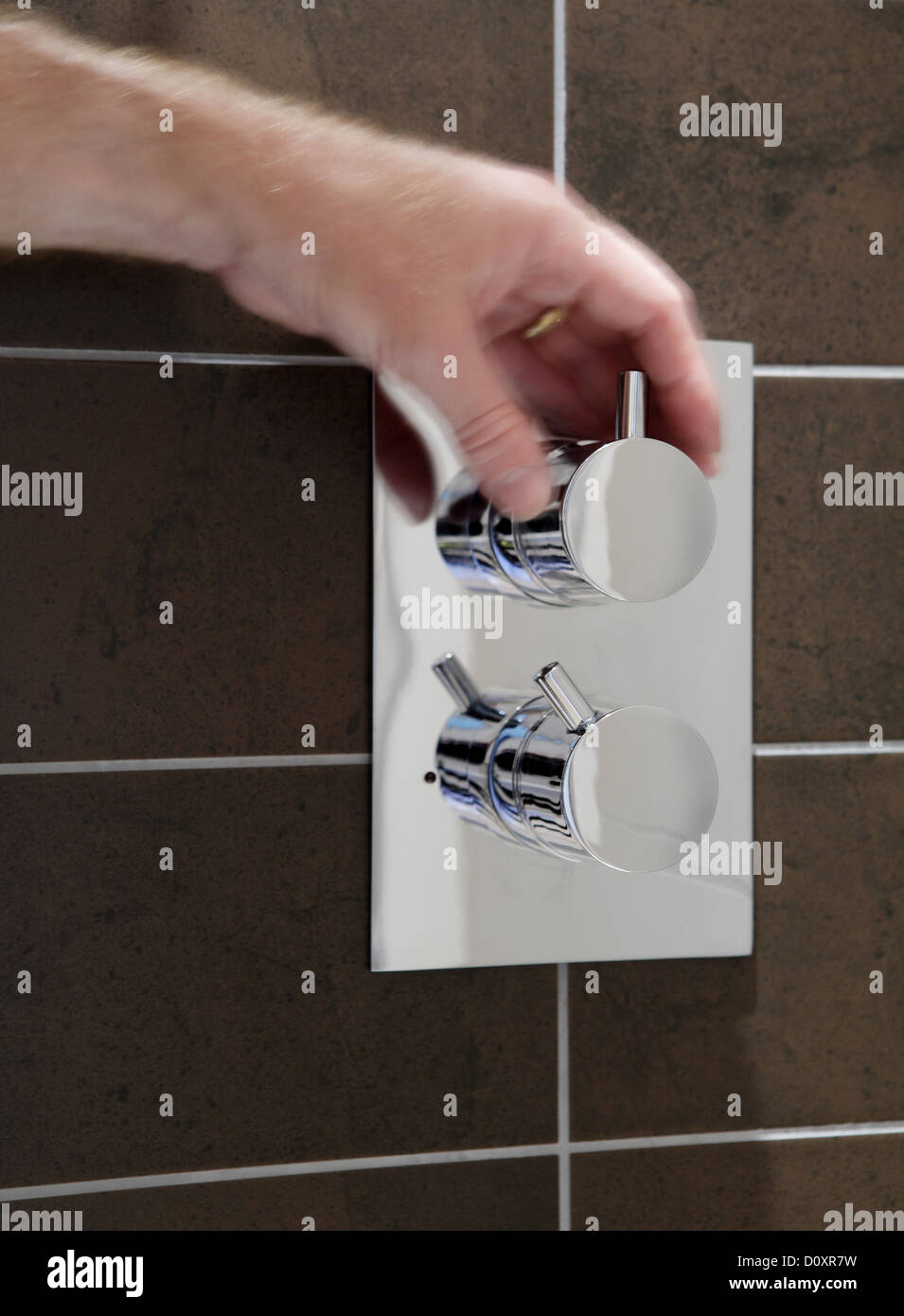 Person turning a knob in the shower Stock Photo Alamy