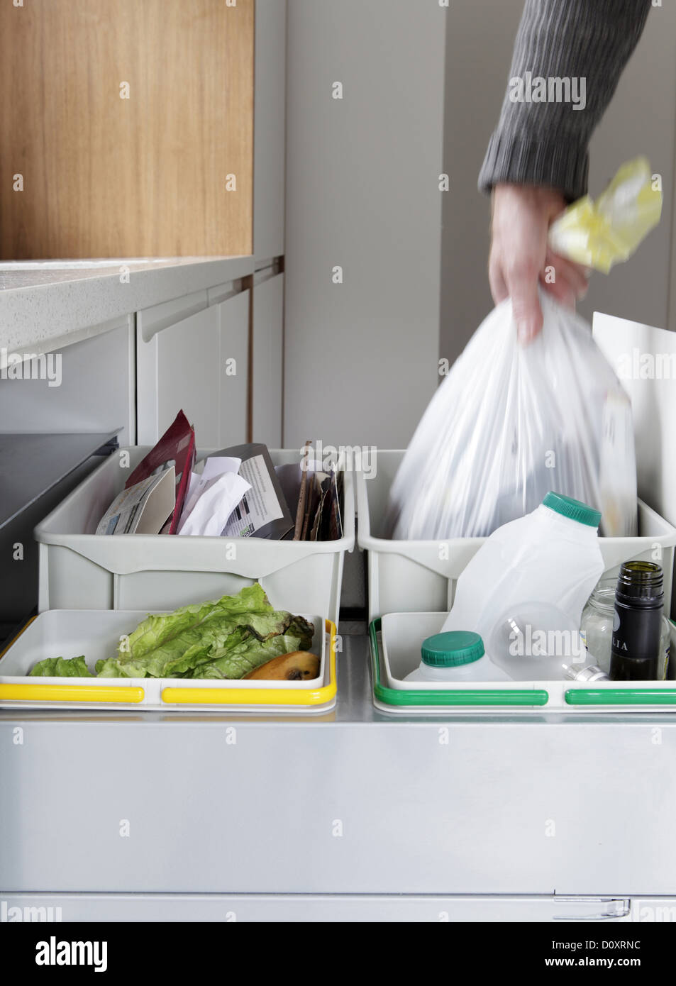 Person Removing Rubbish Bag From Waste And Recycling Drawer Stock