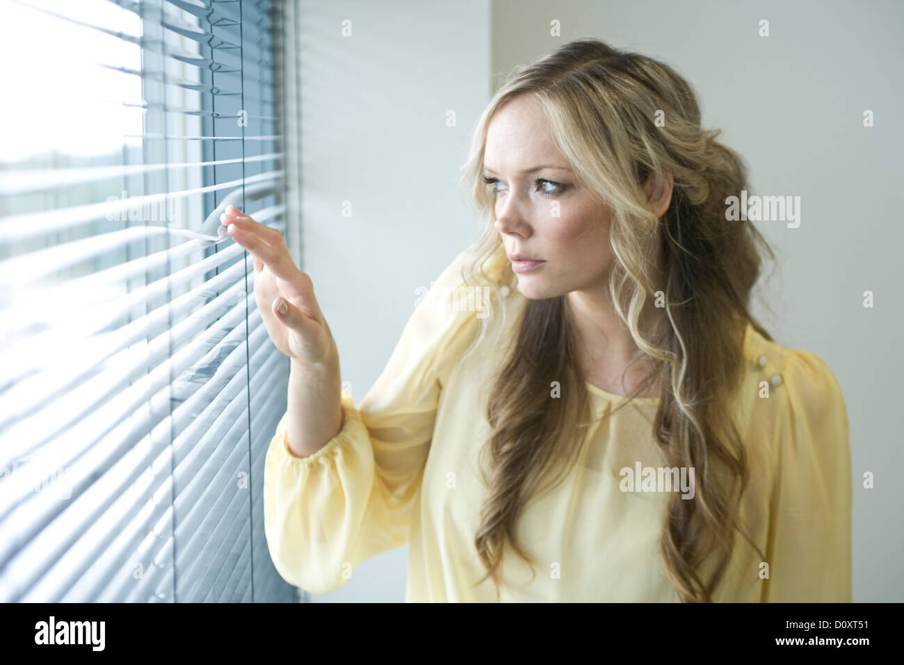 Office Worker Looking Through The Blinds Of Her Office Window Stock Photo Alamy