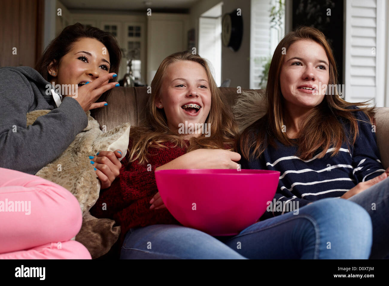 Teenage girls watching movie with popcorn Stock Photo