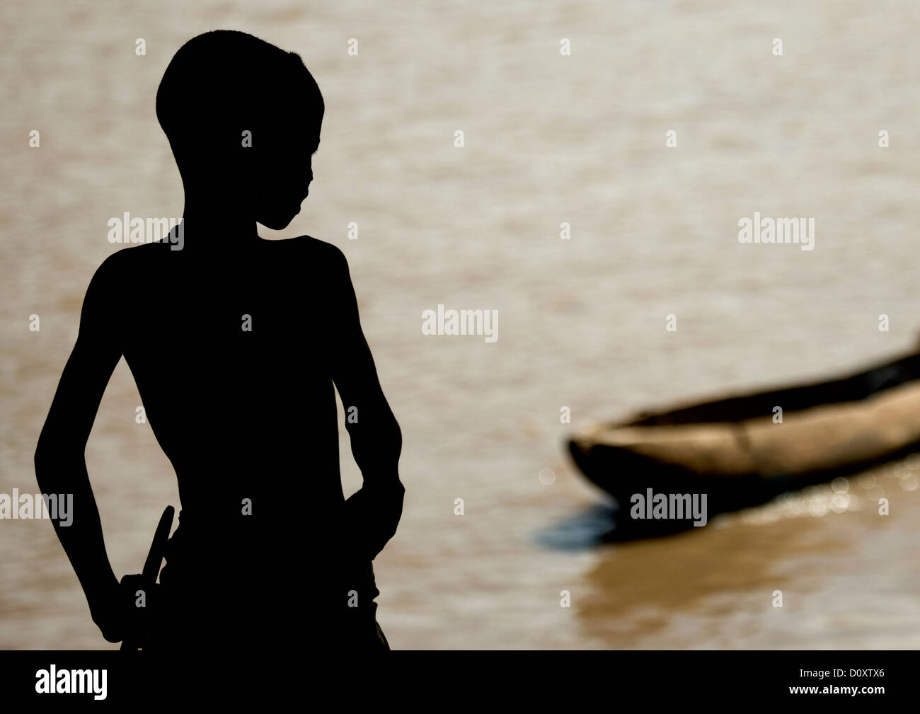 Silhouette Of A Kid Looking At Trunk Boat Used To Cross The Omo River ...