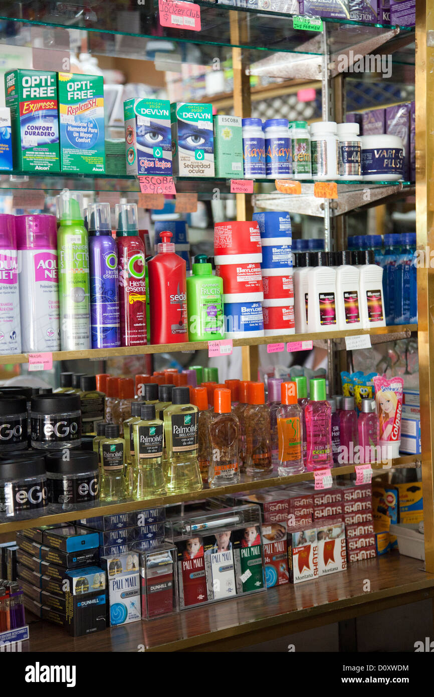 Products, including cigarettes on bottom shelf, on Shelves at Pharmacy in Coyoacan in Mexico City DF Stock Photo