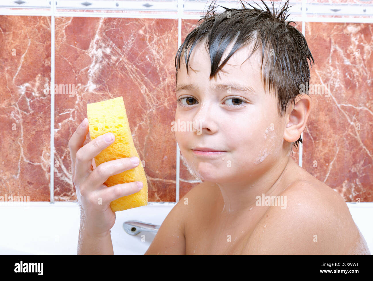 Cute boy with sponge in bathtub Stock Photo Alamy