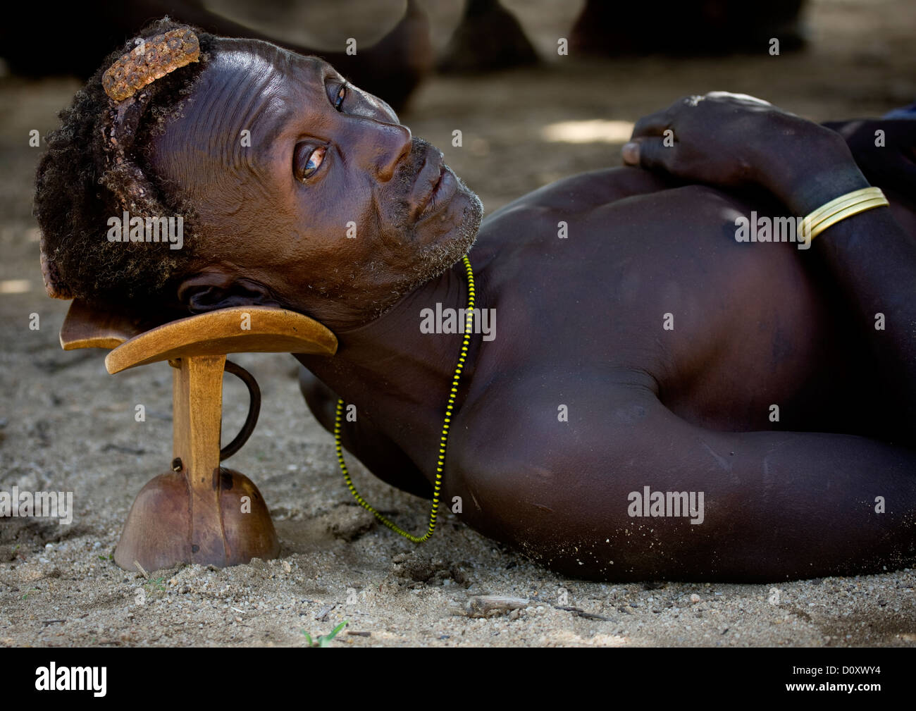 Portrait Of A Karo Man Laying Down On His Headrest, Korcho Village, Omo Valley, Ethiopia Stock Photo