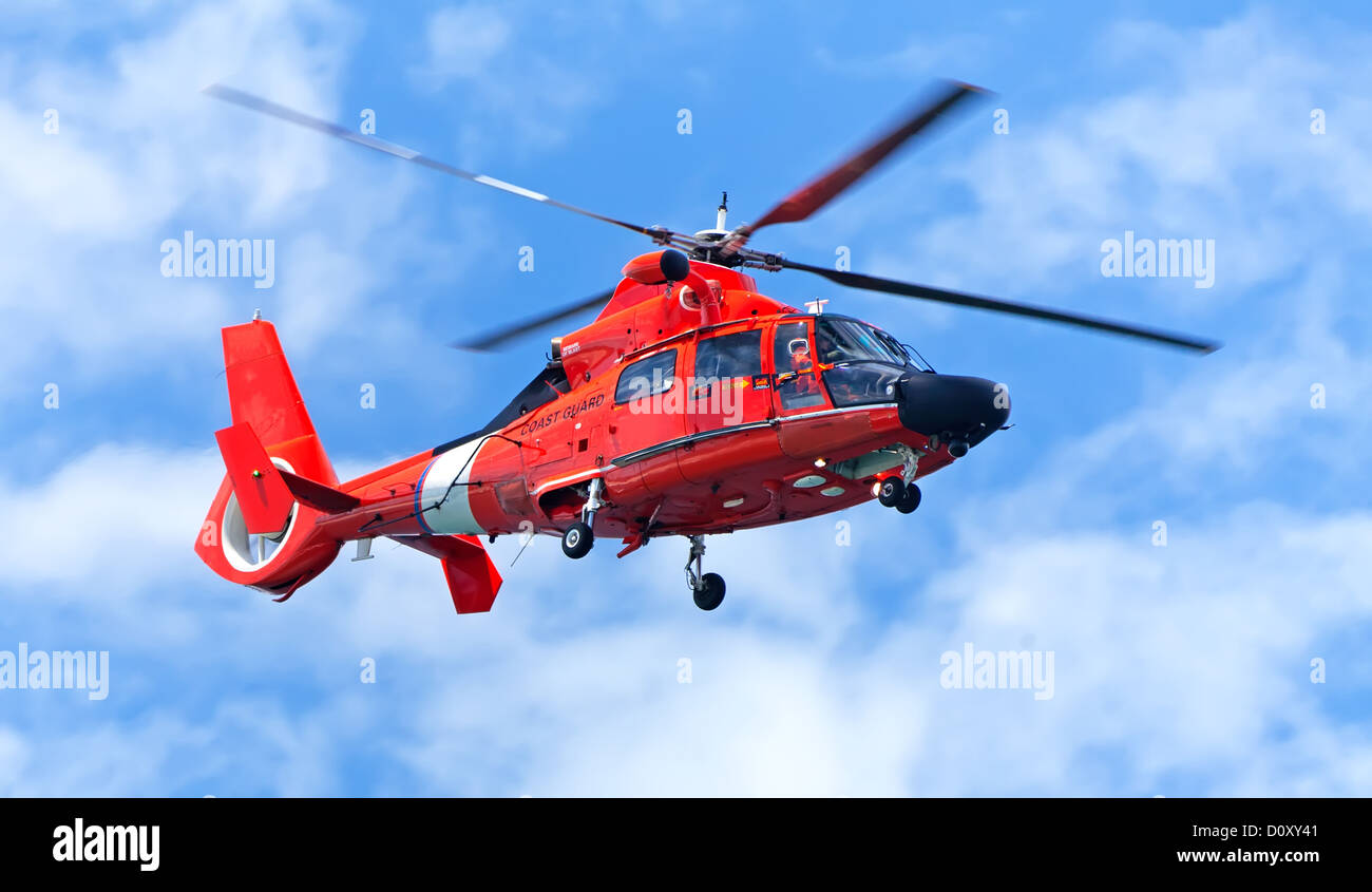 Red rescue helicopter moving in blue sky Stock Photo