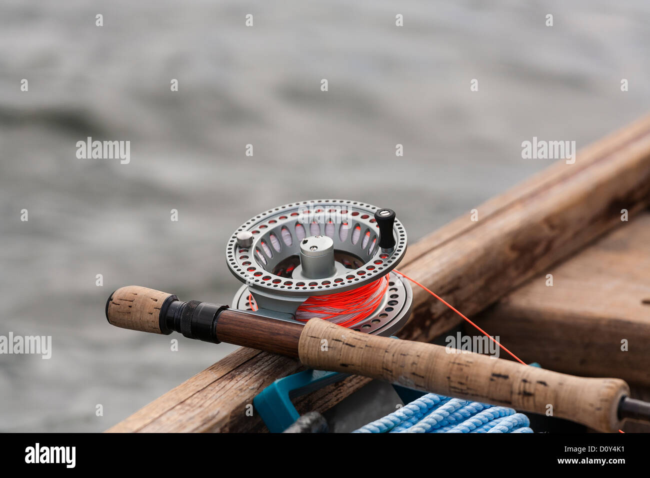 Fly Fishing Reel laying across the gunwale of a boat. Stock Photo