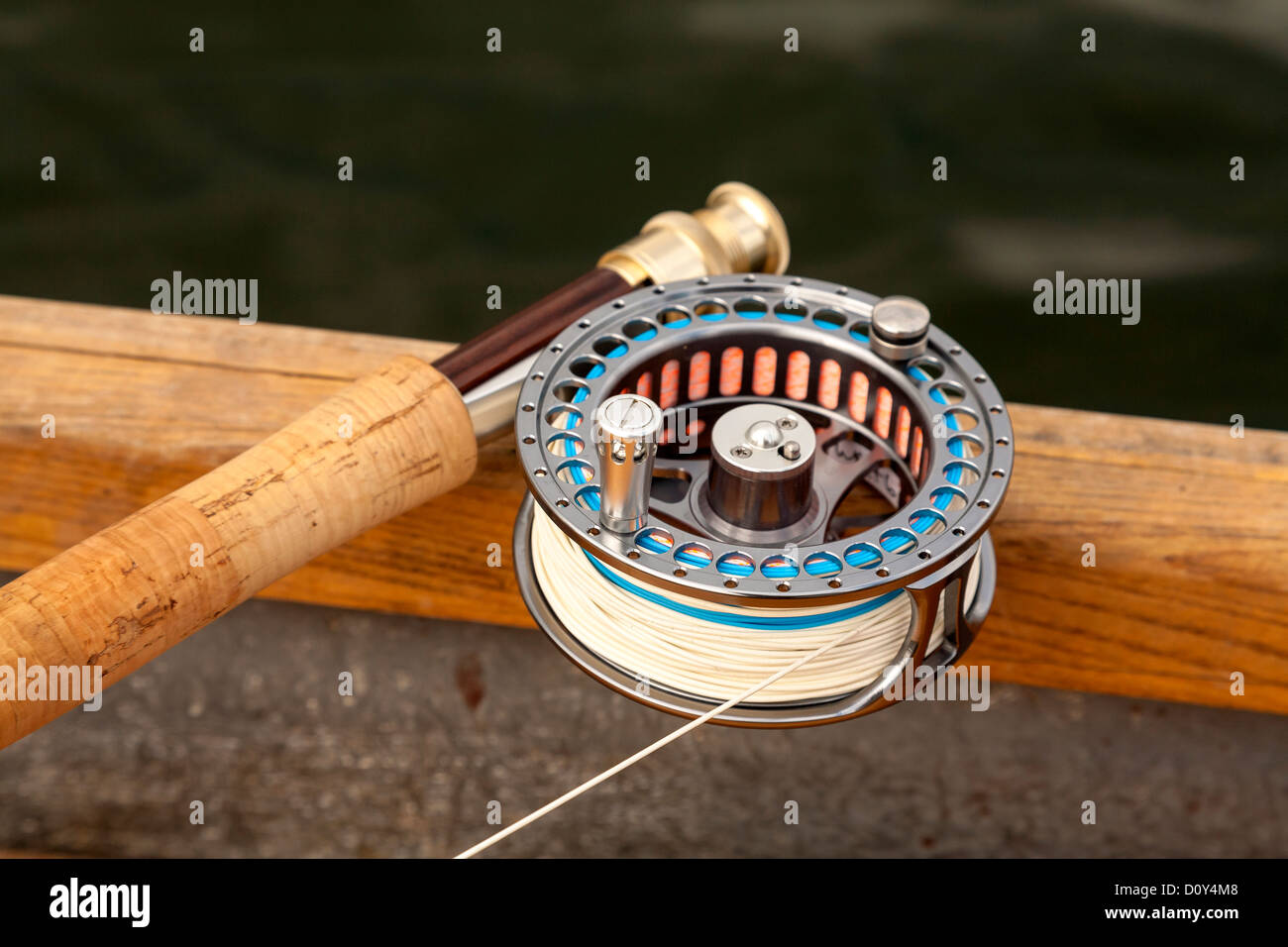 Fly Fishing Reel laying across the gunwale of a boat. Stock Photo