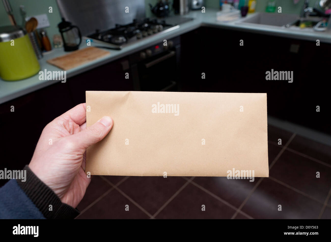 Man at home holding a brown envelope Stock Photo Alamy