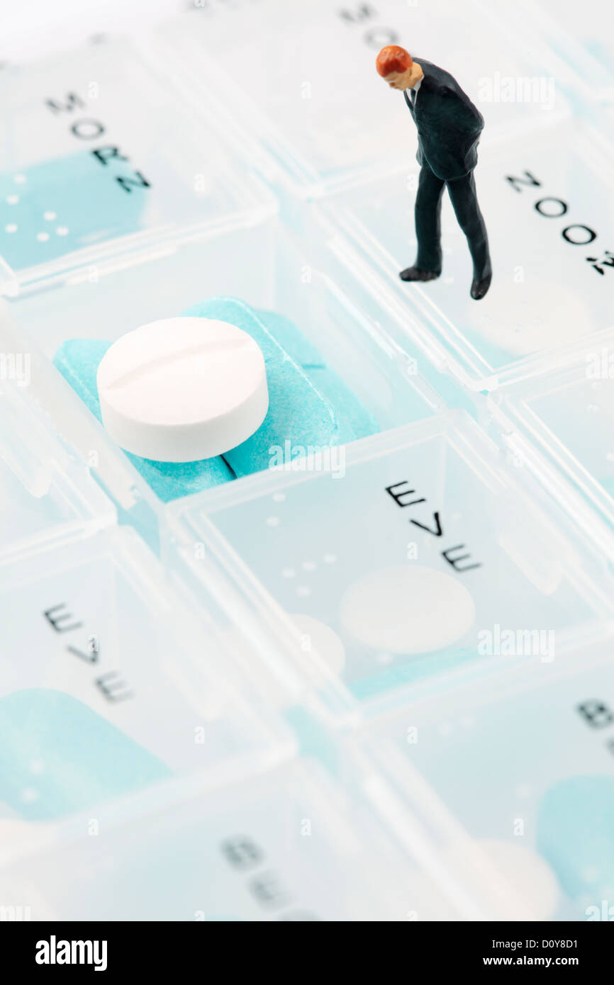 Mini Businessman Figure on Pill Box Stock Photo